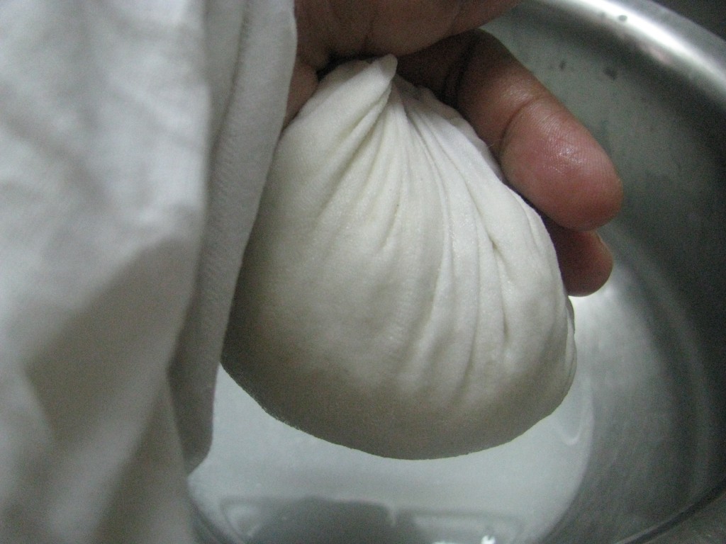 Squueze muslin cloth to remove water from chenna